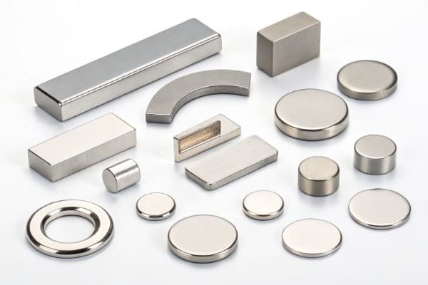 A close-up of various small, coated medical-grade magnets arranged neatly on a sterile surface.