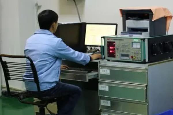 A quality inspector using a digital caliper to measure a small, coated magnet, with a Certificate of Analysis document in the background.